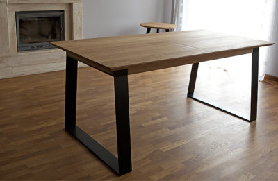 Stôl Holan je charakteristický zladením masívneho dreva s elegantnými čiernymi prvkami kovových podnoží a výklopnej prídavnej dosky v strede plátu.