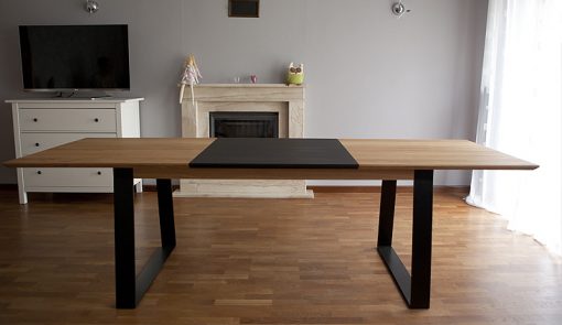 Stôl Holan je charakteristický zladením masívneho dreva s elegantnými čiernymi prvkami kovových podnoží a výklopnej prídavnej dosky v strede plátu.