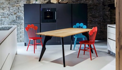 Tri dizajnové stoličky PAF v modrej a červenej farbe v interiéri kuchyne.