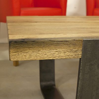 Detail na spojenie dreveného plátu a oceľových nôh stola MERAN.
