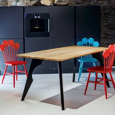 Tri dizajnové stoličky PAF v modrej a červenej farbe v interiéri kuchyne.